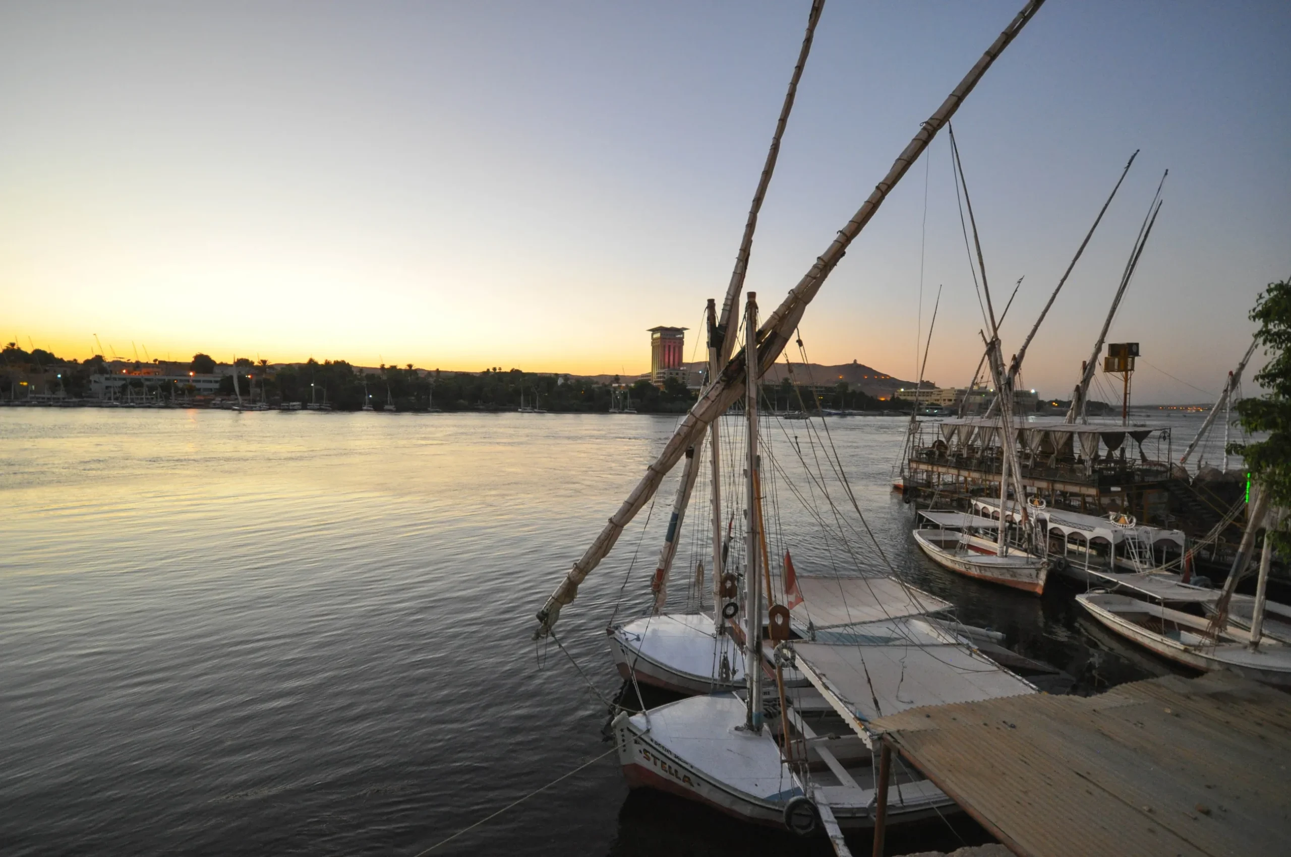 aswan nile feluccas sunset egypt scaled 阿斯旺尼罗河帆船与河岸景观,展示埃及南部路线和尼罗河旅行核心